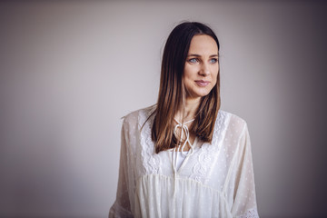 Portrait of beautiful brunette with blue eyes smiling and looking away.