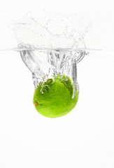 Fototapeta na wymiar Falling of fresh lime into water against white background