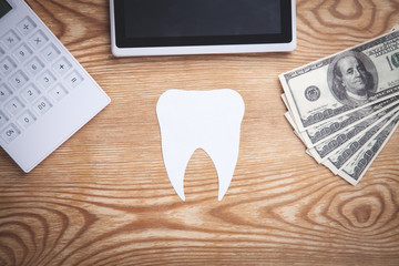 Paper Tooth with money and business objects.