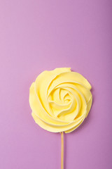 yellow Rose candy   in pastel colors on a wooden stick on a grey  background, Valentine, Mother's Day.