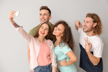 Obraz premium Friends taking selfie on grey background