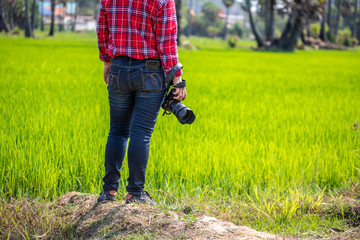 Woman photographer with camera on the rice fields.