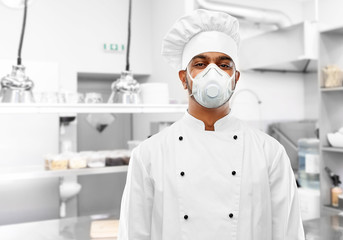 health protection, safety and pandemic concept - indian male chef cook wearing face protective mask or respirator over restaurant kitchen background