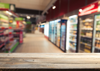 Supermarket background, Counter over blur grocery background, Wooden desk, table, shelf and blur woman shopping at supermarket, Wood counter for grocery store retail product display backdrop, template