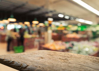 Supermarket background, Counter over blur grocery background, Wooden desk, table, shelf and blur woman shopping at supermarket, Wood counter for grocery store retail product display backdrop, template