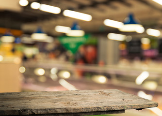 Supermarket background, Counter over blur grocery background, Wooden desk, table, shelf and blur woman shopping at supermarket, Wood counter for grocery store retail product display backdrop, template
