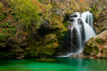 waterfall with milky water on the mountain and mountain vegetation