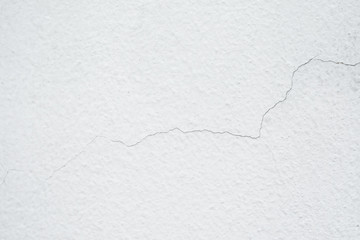 Wall with cracked white paint, texture cement large crack for background