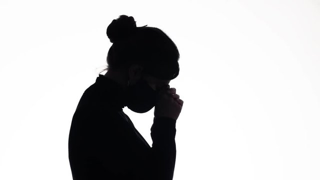 silhouette young woman in a protective mask praying on white isolated background, girl raised her head up asking for help, health concept,world problem