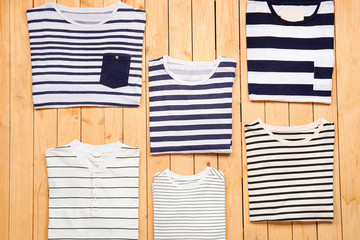 Different stylish t-shirts on wooden background