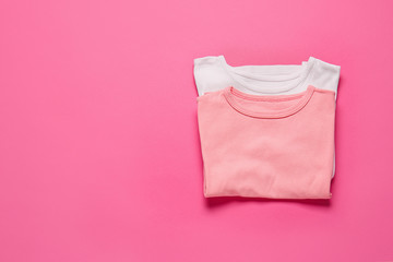 Stylish t-shirts on color background