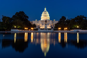 Capitol hill building at night illuminated with light with lake reflection Washington DC.