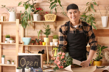Asian male florist working in shop