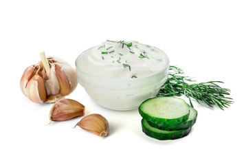 Delicious yogurt sauce with cucumber in bowl on white background