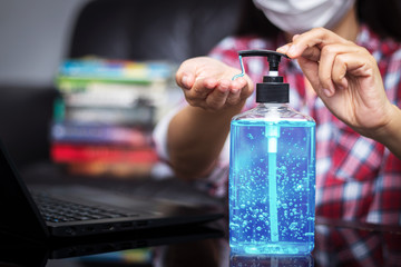 people washing hand by hand sanitizer alcohol gel for cleaning and disinfection, before typing on keyboard for working. prevention of spreading of germs during infections of COVID-19 Coronavirus