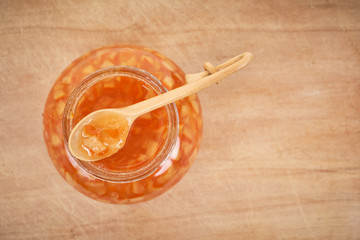 Orange homemade jam on wooden background. Top view.
