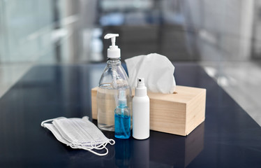 hygiene and disinfection concept - close up of different hand sanitizers, liquid soap, face...