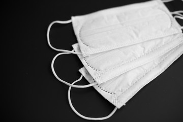 medicine, healthcare and safety concept - close up of white face protective medical masks on black...