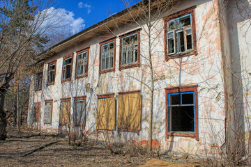 Old abandoned building - empty windows with broken glasses. 