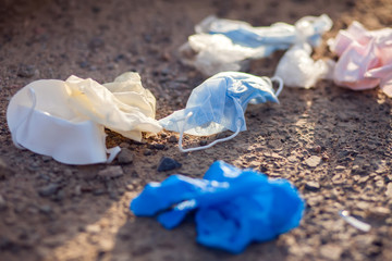 Used medical masks and gloves on ground on the street. Environmental pollution concept