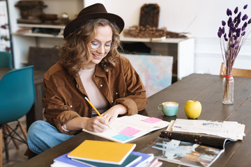 Image of joyful woman smiling while studying with exercise books