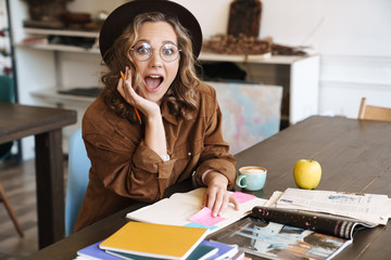 Image of woman expressing surprise while studying with exercise books