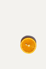 simple composition of lonely slice of orange placed under the sun in the afternoon, harsh shadow