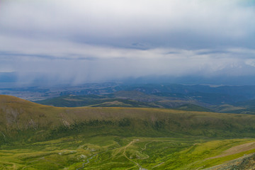 Fototapeta premium Panoramic view of a Altay mountain valley. Summer time, soft light, white clouds, blue sky. Dark day.