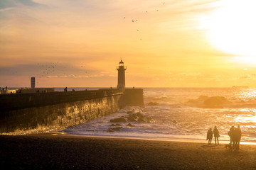 Felgueiras Lighthouse on shore of Atlantic ocean in Porto, Portugal at sunset