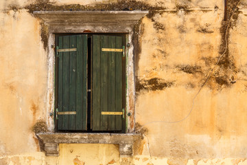 Fototapeta na wymiar Closed shutters on the window in the historic centre of Omis, Croatia