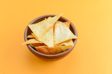 Nacho cheese tortilla chips in a bowl. Crisp golden unhealthy chips, junk food, fast food concept.