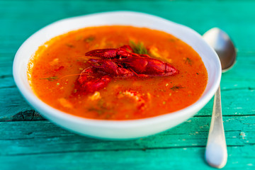 Crayfish soup on a wooden background.