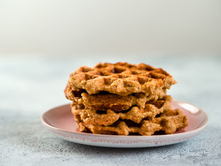 Easy healthy gluten free oat waffles with copy space. Stack of appetizing homemade waffles with oat flour on plate over light gray cement background