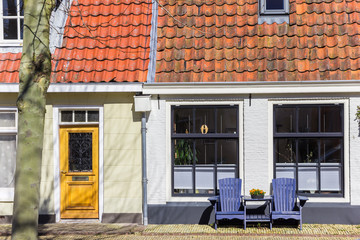 Fototapeta na wymiar Wooden chairs in front of a house in Harlingen, Netherlands
