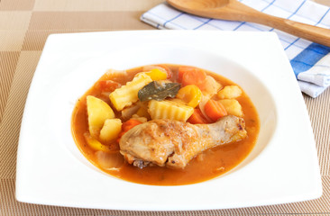 close up of chicken stew with tomatoes, potatoes, carrot, thym, and ketchup.