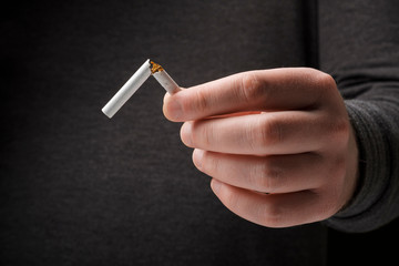 Male hand breaking a cigarette. Stop smoking cigarettes concept. Quit bad habit, healthy lifestyle concept. No smoking. Do not choose wrong lifestyle..