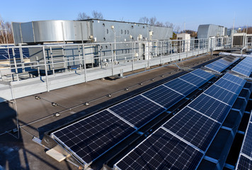 Solar panels on roof and air conditioning in background.