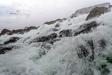 Splashes of the Niagara falls in a sunny day