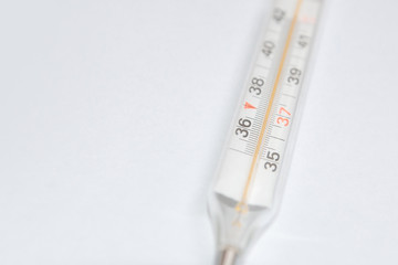 On white surface in center is placed a thermometer to measure the temperature. Glass mercury...