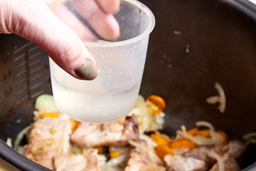 Cooking. Roasting pieces of meat with carrots or onions in a multicooker bowl