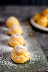 Eclair, choux filled vanilla custard cream and dusted with icing,  dessert on a plate with copy space