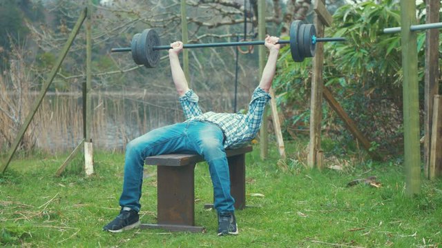 Bench pressing weight young man home outdoor gym