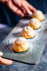 Eclair, choux filled vanilla custard cream and dusted with icing,  dessert on a plate with copy space