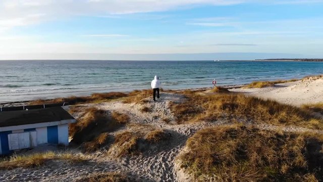 Guy walking on beach in Sweden winter time