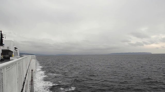 View from a Ferry moving through the water on a cold and cloudy day, on Vancouver Island