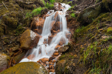 City Cesis, Latvia. Old waterfall with green moss and red rocks.