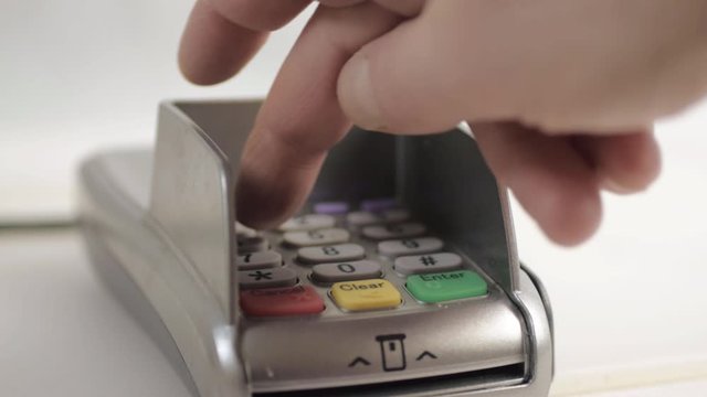 Hand tapping in pin number to pdq payment machine close up shot