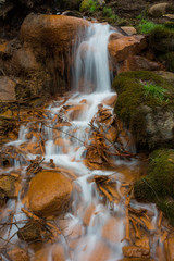 Obraz premium City Cesis, Latvia. Old waterfall with green moss and red rocks.
