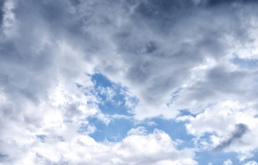 the bright blue sky in the summer midday with storm clouds