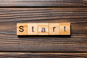 Start word written on wood block. Start text on wooden table for your desing, concept